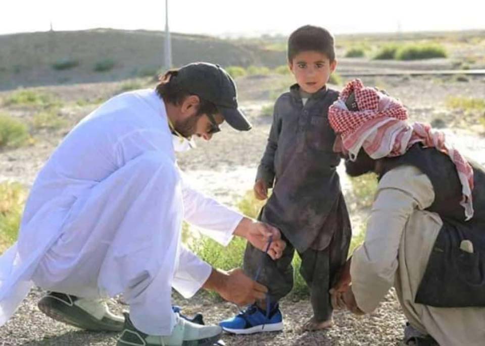 نوشکی ، شاہد خان آفریدی اپنے گاڑی سے اتر کر کمسن غریب بچے کو نئے جوتے پہنائے